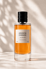 Perfume bottle labeled 'Arancia Essence' by Alamara on a neutral background