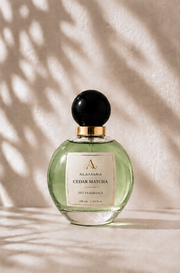 Perfume bottle labeled 'Alamara Cedar Matcha' on a neutral background