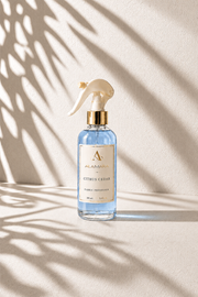 Spray bottle on a beige background with leaf shadows