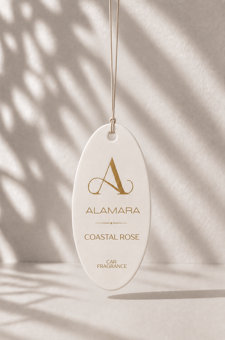 Alamara car fragrance hanging against a neutral background with shadows.