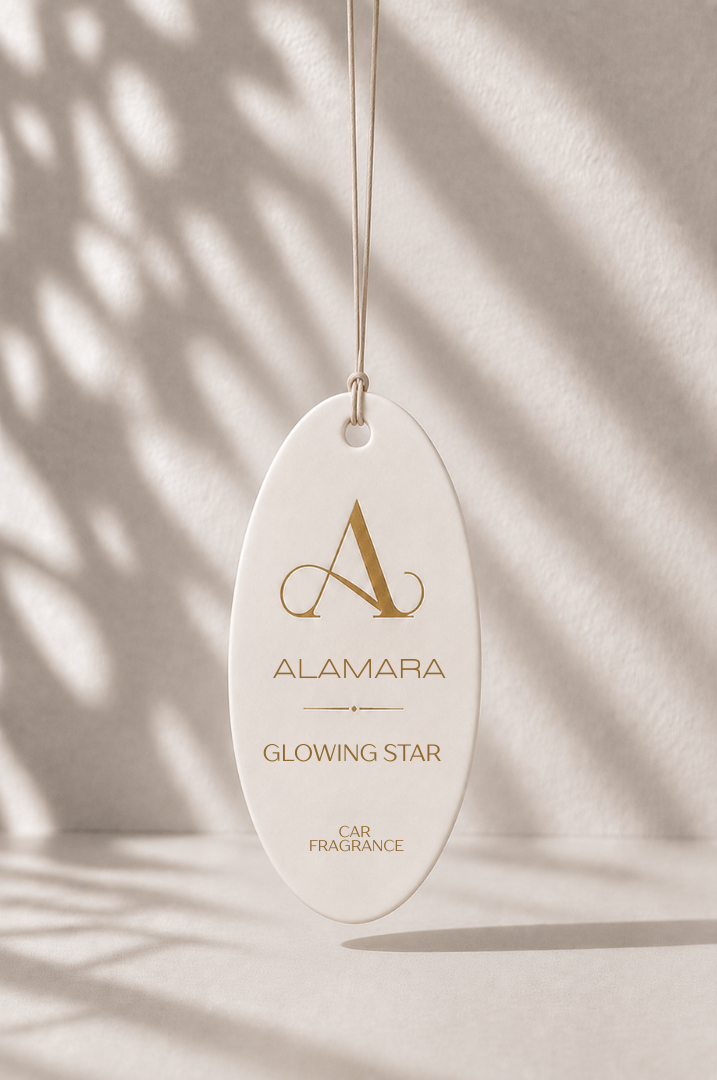 Alamara Glowing Star Car Fragrance hanging against a neutral background with shadows.