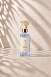 Spray bottle labeled 'Moonlight Lotion' on a beige background with shadow patterns